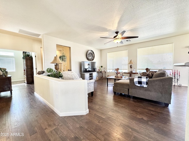 living area featuring baseboards, a textured ceiling, ceiling fan, and dark wood finished floors