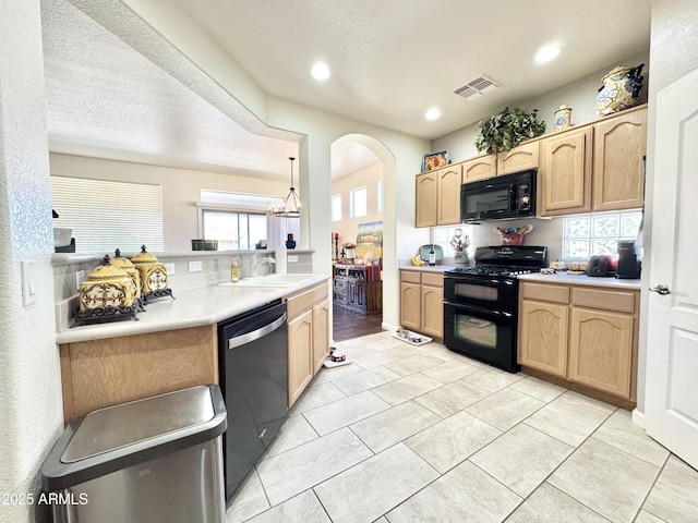 kitchen with black appliances, visible vents, light brown cabinetry, and a sink