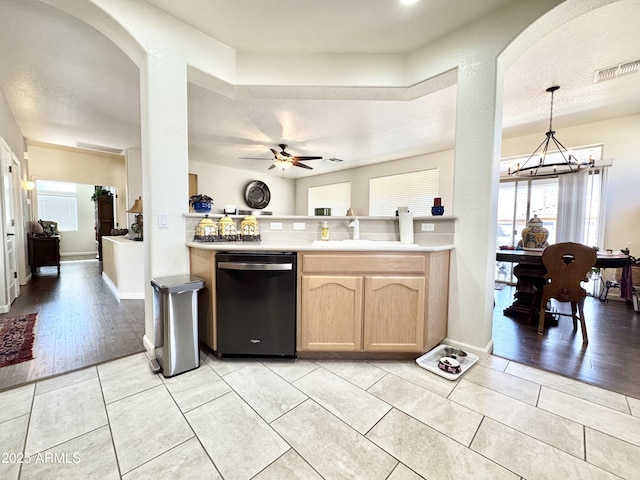 kitchen with light brown cabinetry, ceiling fan with notable chandelier, a sink, arched walkways, and dishwasher