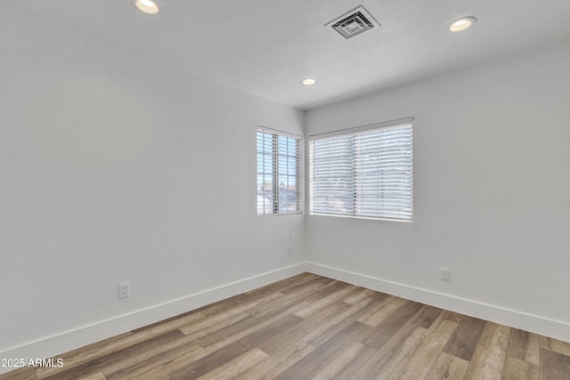 spare room featuring recessed lighting, visible vents, light wood-style flooring, and baseboards