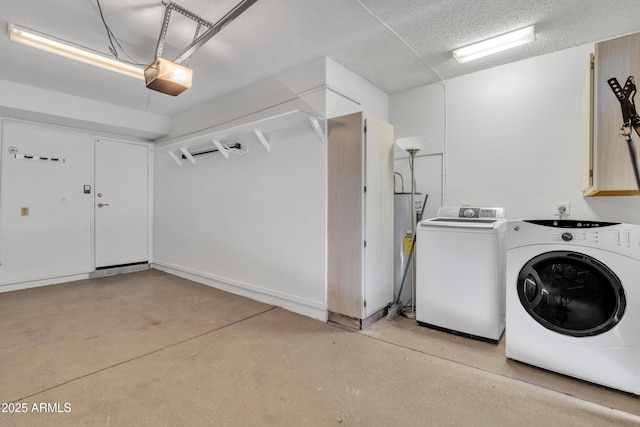 laundry room featuring a garage, a textured ceiling, and washing machine and clothes dryer