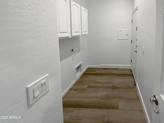 washroom with wood finished floors, cabinet space, baseboards, and hookup for an electric dryer