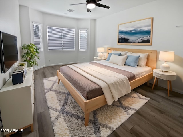 bedroom featuring ceiling fan, visible vents, baseboards, and wood finished floors