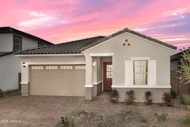 24223 W Illini St, Buckeye, AZ 85326 - view of front of property featuring decorative driveway, stucco siding, and an attached garage
