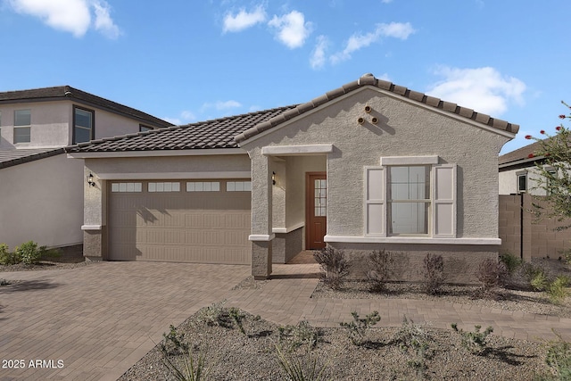 24223 W Illini St, Buckeye, AZ 85326 - view of front of house featuring an attached garage, decorative driveway, a tile roof, and stucco siding