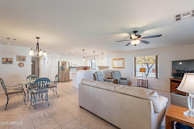 living room with light tile patterned floors and ceiling fan with notable chandelier