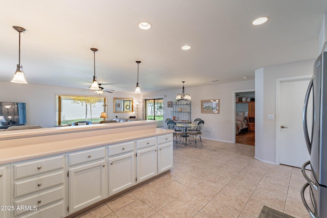 kitchen featuring pendant lighting, white cabinets, ceiling fan, stainless steel fridge, and light tile patterned floors