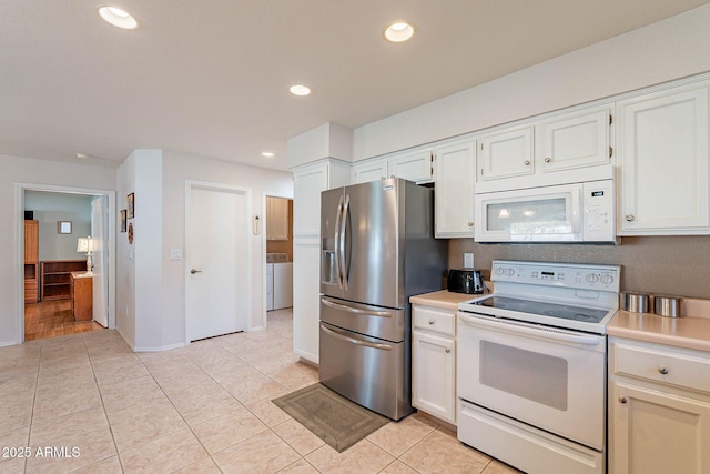 kitchen with white cabinetry, light tile patterned floors, and white appliances