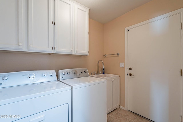 laundry area featuring separate washer and dryer, sink, light tile patterned floors, and cabinets