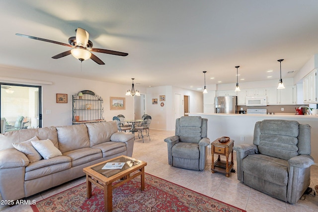 living room featuring sink, light tile patterned floors, and ceiling fan with notable chandelier