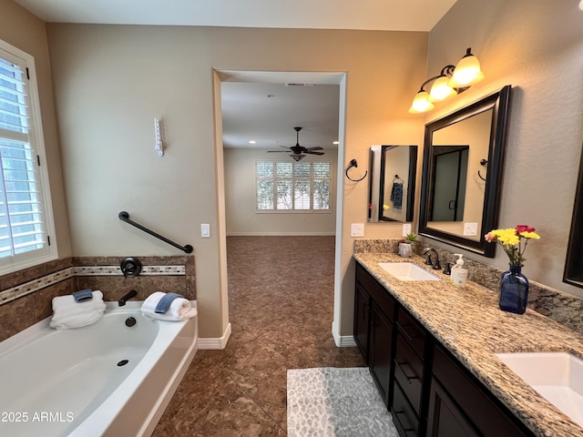 bathroom featuring a bath, double vanity, baseboards, and a sink