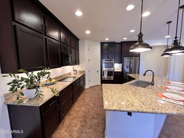 kitchen with light stone counters, a breakfast bar, recessed lighting, appliances with stainless steel finishes, and a sink