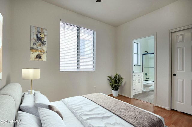 bedroom featuring light hardwood / wood-style flooring and ensuite bath