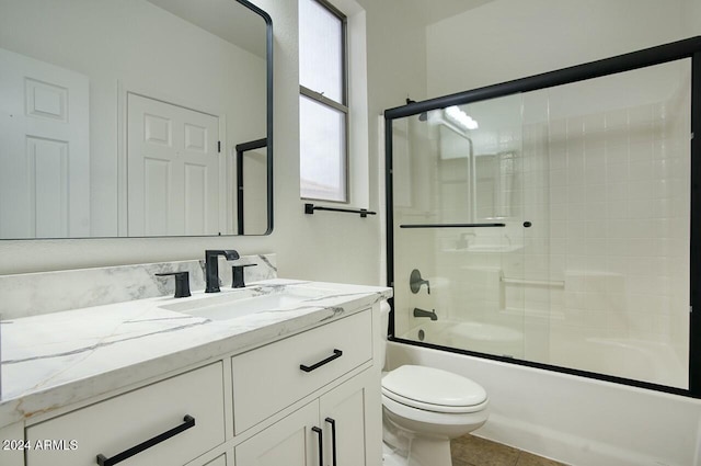 full bathroom with tile patterned floors, vanity, toilet, and enclosed tub / shower combo