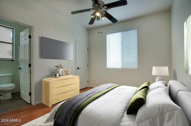 bedroom featuring ensuite bathroom, light hardwood / wood-style flooring, and ceiling fan