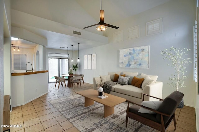 tiled living room with ceiling fan and sink