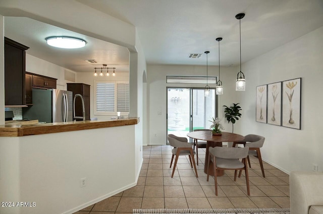 dining area featuring light tile patterned floors and track lighting