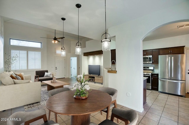 tiled dining space with ceiling fan