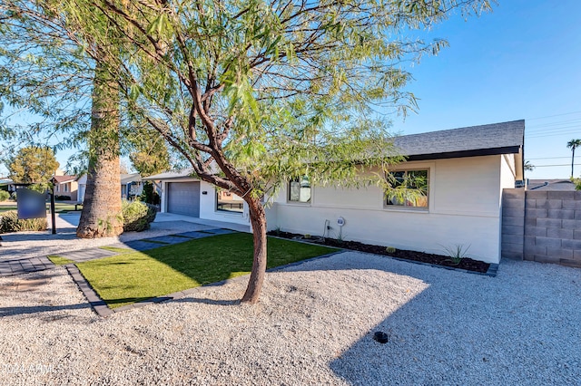 single story home featuring a garage and a front lawn