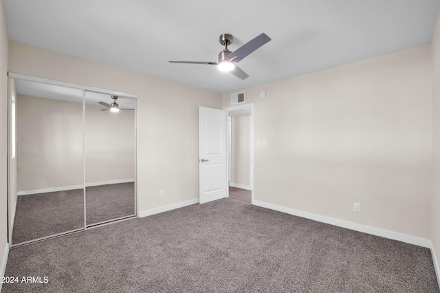 unfurnished bedroom with a closet, dark colored carpet, and ceiling fan