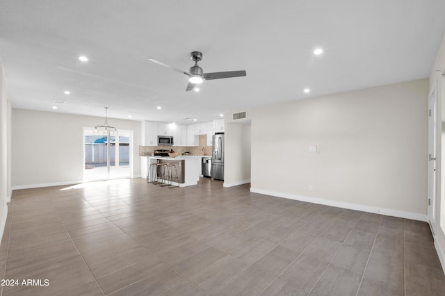 unfurnished living room featuring ceiling fan