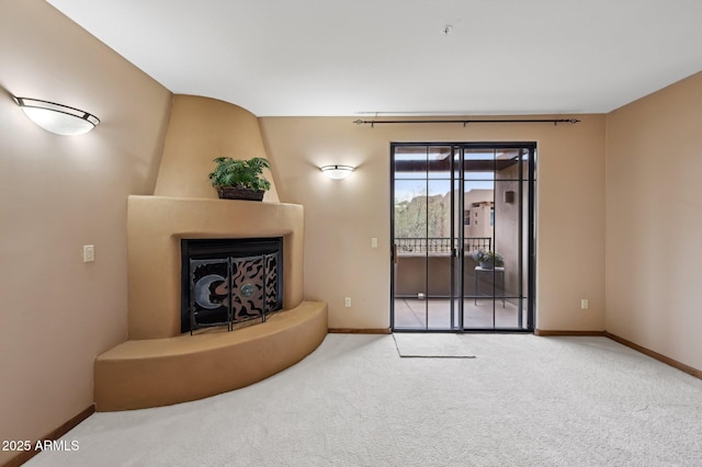 carpeted living room with a fireplace and baseboards