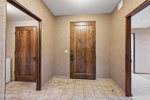 foyer entrance with baseboards, visible vents, and light tile patterned flooring