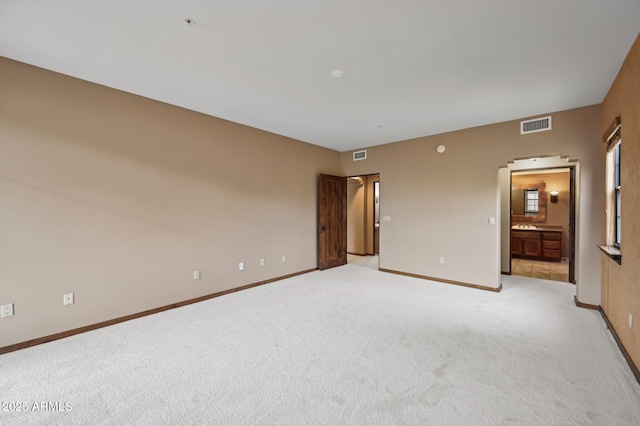 spare room with light carpet, visible vents, and baseboards