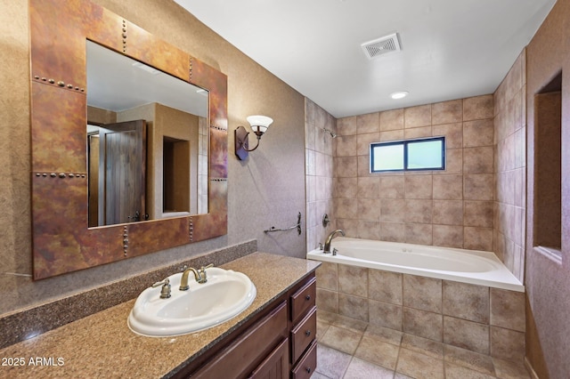 bathroom featuring tiled shower / bath combo, vanity, and visible vents