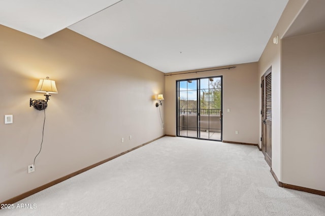 unfurnished room featuring light carpet and baseboards