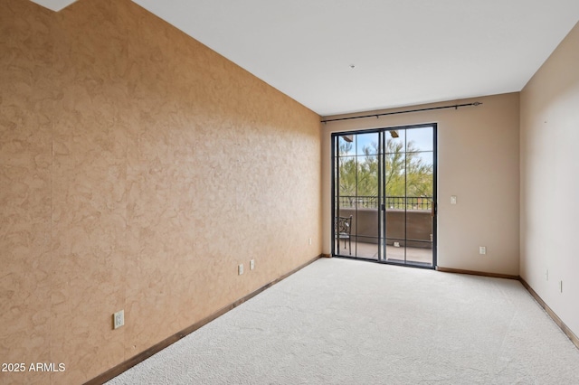 carpeted spare room featuring baseboards