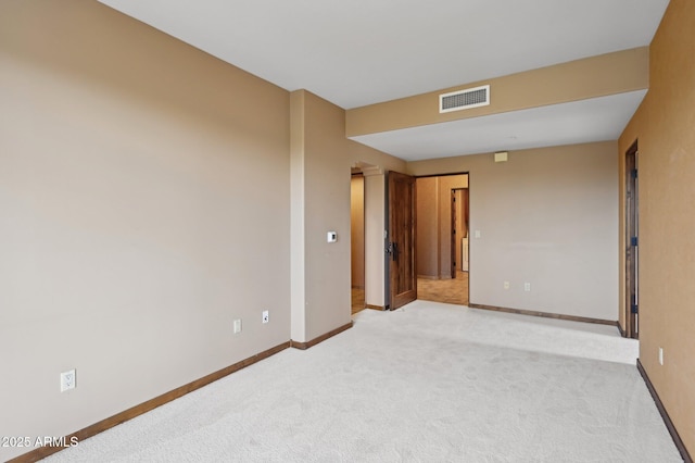 carpeted empty room featuring visible vents and baseboards