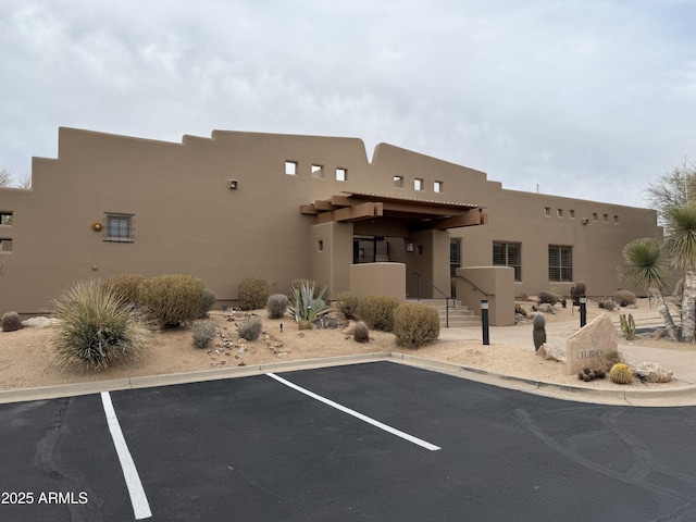 view of building exterior with uncovered parking