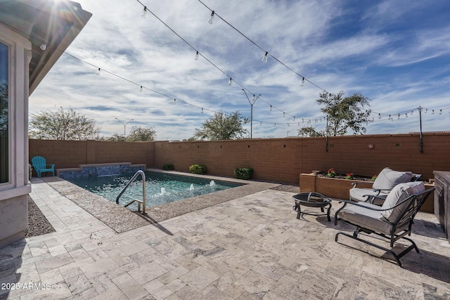 view of pool featuring a patio area, pool water feature, and an outdoor fire pit