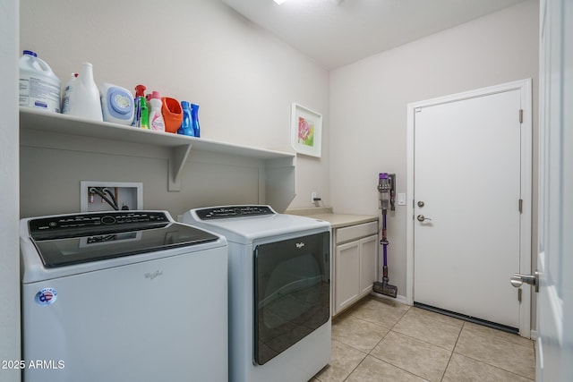 laundry area featuring cabinets, light tile patterned floors, and independent washer and dryer