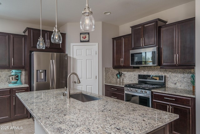 kitchen featuring light stone counters, sink, a kitchen island with sink, and appliances with stainless steel finishes