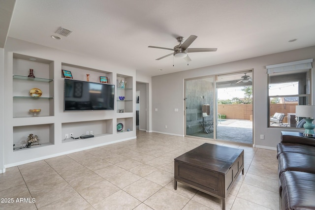 living room with light tile patterned floors, built in shelves, and ceiling fan