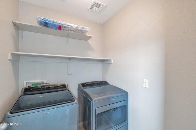 laundry room featuring washer and clothes dryer, visible vents, and laundry area