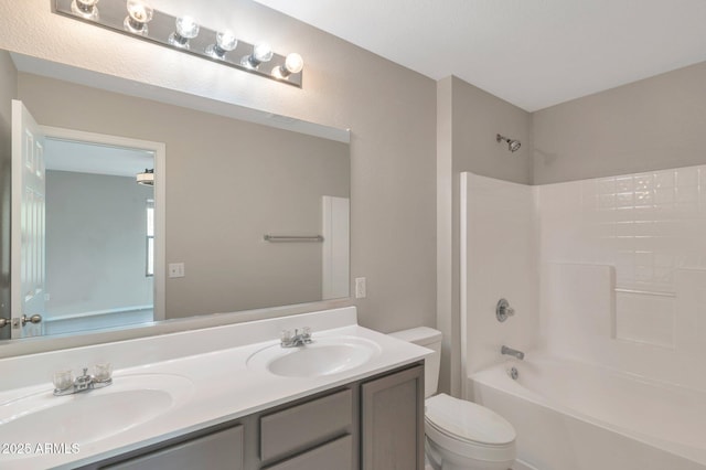 full bath with double vanity, toilet, shower / washtub combination, and a sink