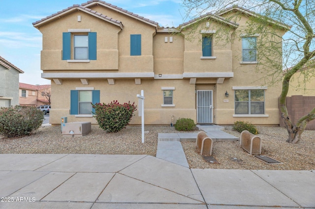 multi unit property featuring stucco siding and a tile roof