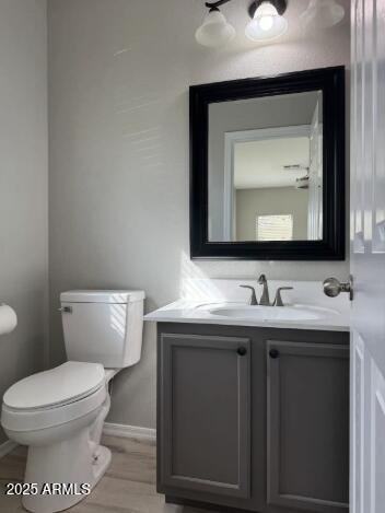 9621 N 82nd Ln, Peoria, AZ 85345 - bathroom with toilet, vanity, baseboards, and wood finished floors