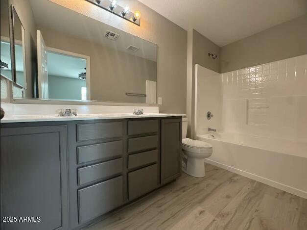9621 N 82nd Ln, Peoria, AZ 85345 - full bathroom with double vanity, toilet, wood finished floors, and bathing tub / shower combination