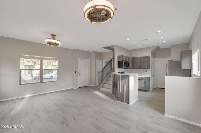 kitchen with baseboards, recessed lighting, gray cabinets, light wood-style floors, and appliances with stainless steel finishes