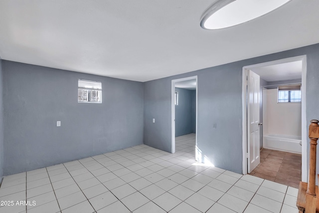 tiled empty room featuring plenty of natural light