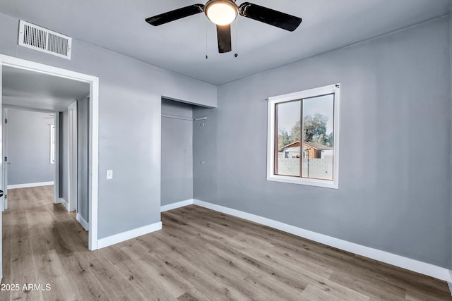 unfurnished bedroom featuring ceiling fan, a closet, and light hardwood / wood-style flooring