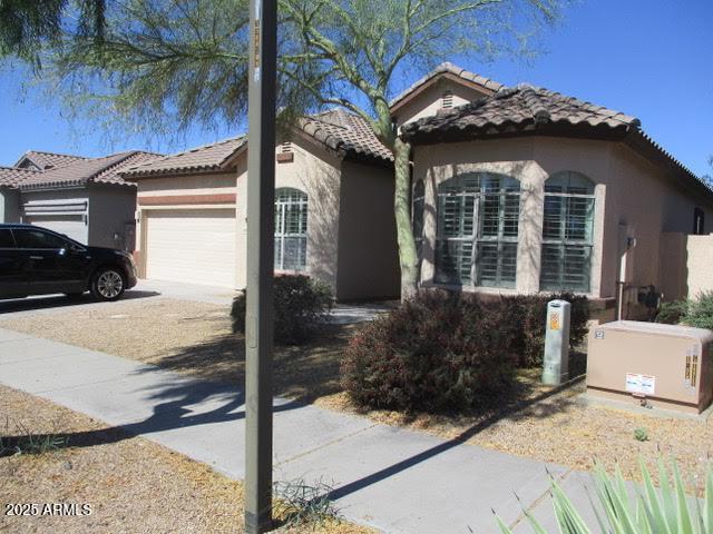 32020 N 23rd Ave, Phoenix, AZ 85085 - view of front facade featuring an attached garage, a tiled roof, stucco siding, and concrete driveway