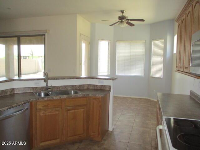 32020 N 23rd Ave, Phoenix, AZ 85085 - kitchen featuring stainless steel dishwasher, a sink, ceiling fan, dark countertops, and light tile patterned floors