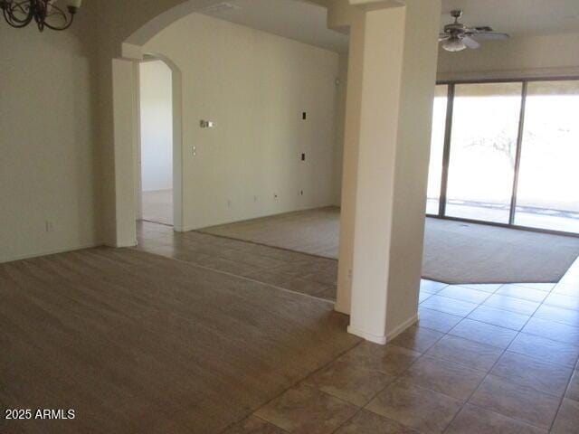 32020 N 23rd Ave, Phoenix, AZ 85085 - carpeted empty room with arched walkways, a ceiling fan, tile patterned floors, and a chandelier