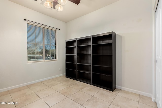 tiled spare room featuring ceiling fan