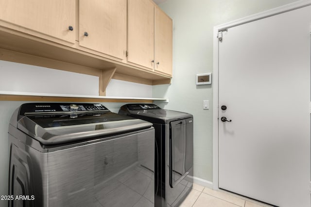 laundry room with cabinets, light tile patterned floors, and independent washer and dryer